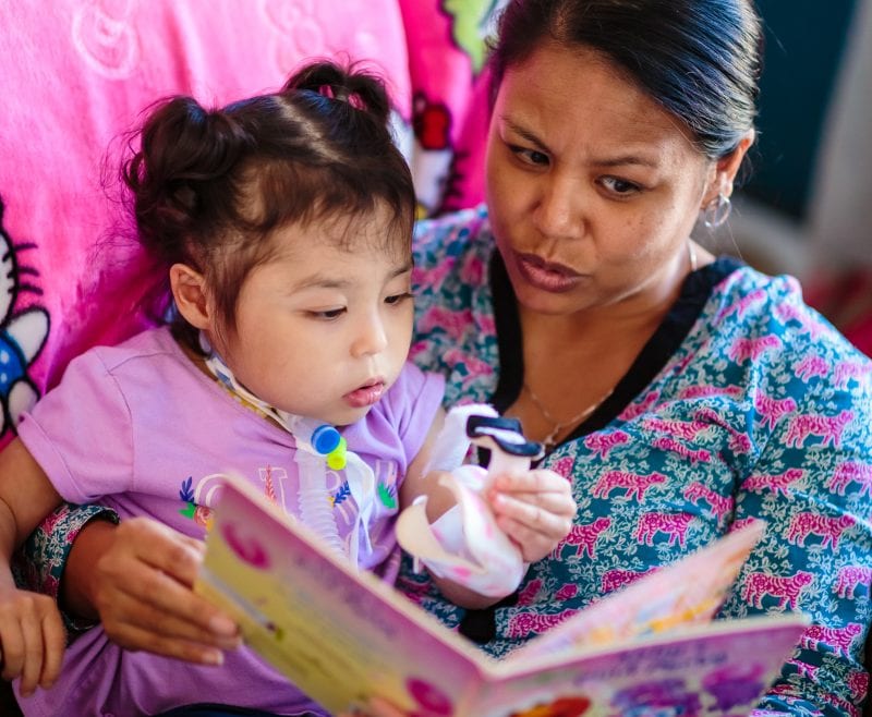 nurse reading a book to little girl