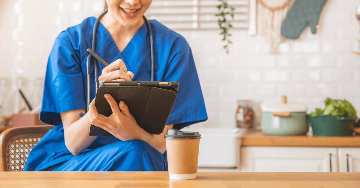 nurse in blue scrubs holding an iPad
