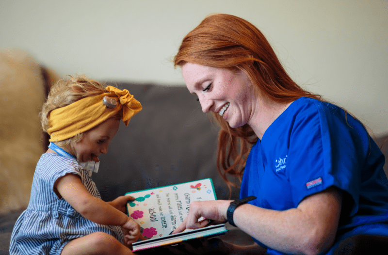 nurse reading a book to a patient - Build Communication with Non-Verbal Pediatric Patients